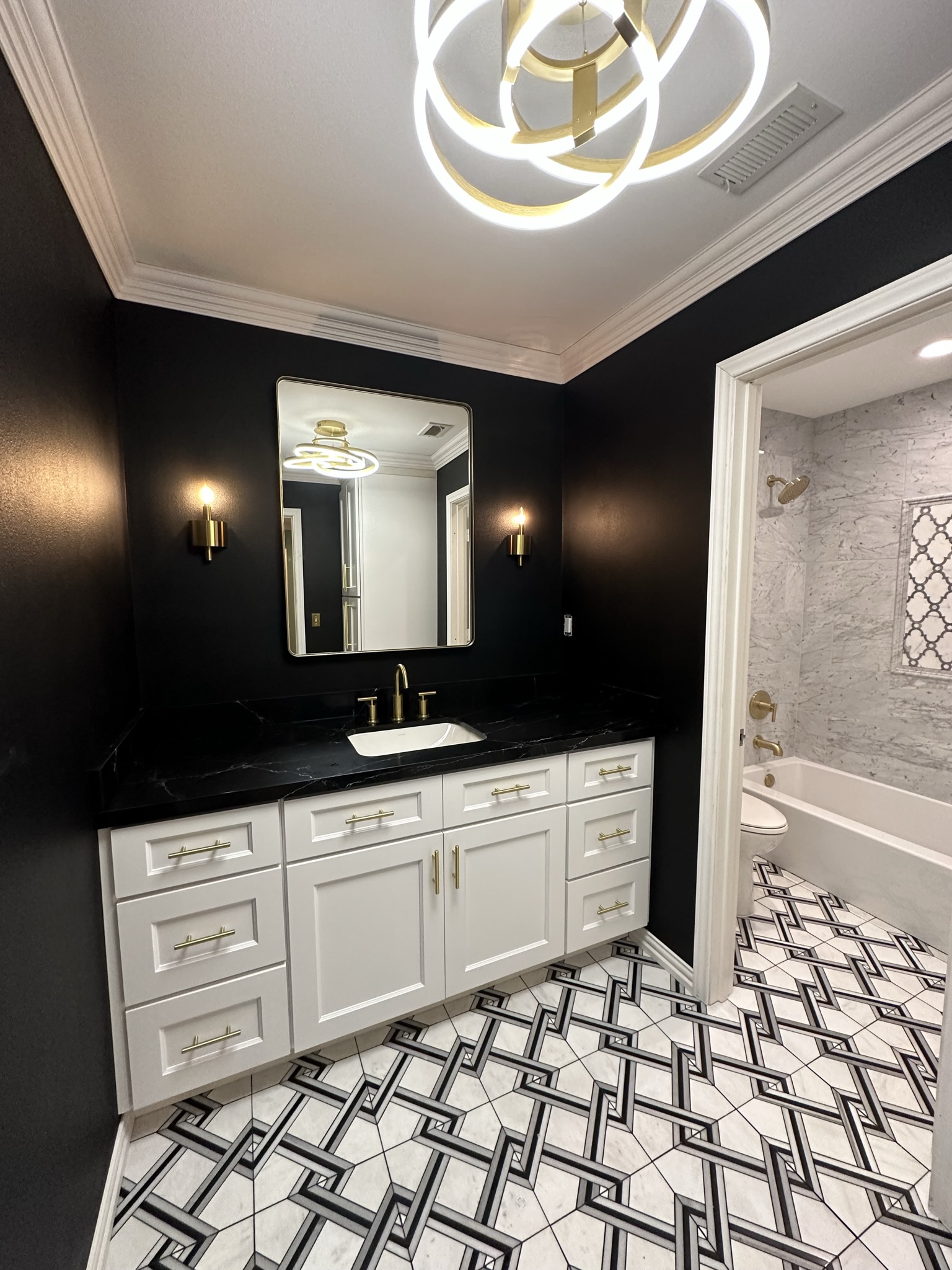 Luxury bathroom with black walls, white vanity and gold fixtures