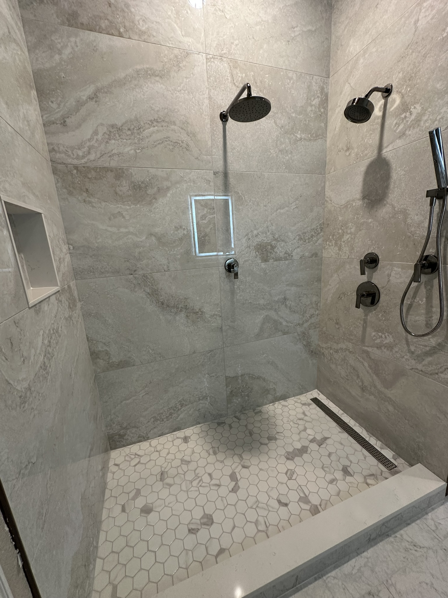 Large format grey marble shower with dual shower heads