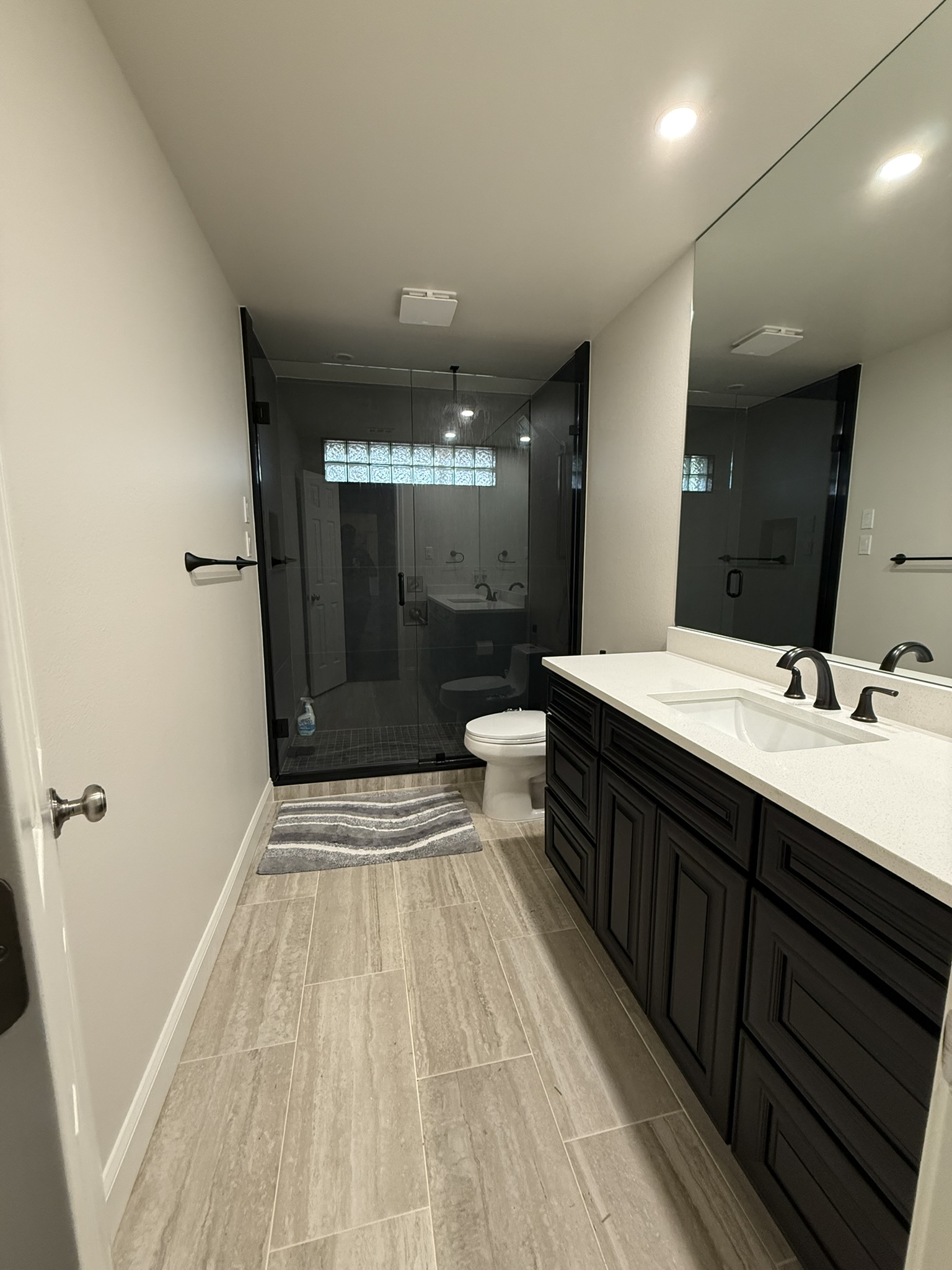 Modern bathroom with black vanity and wood-look tile