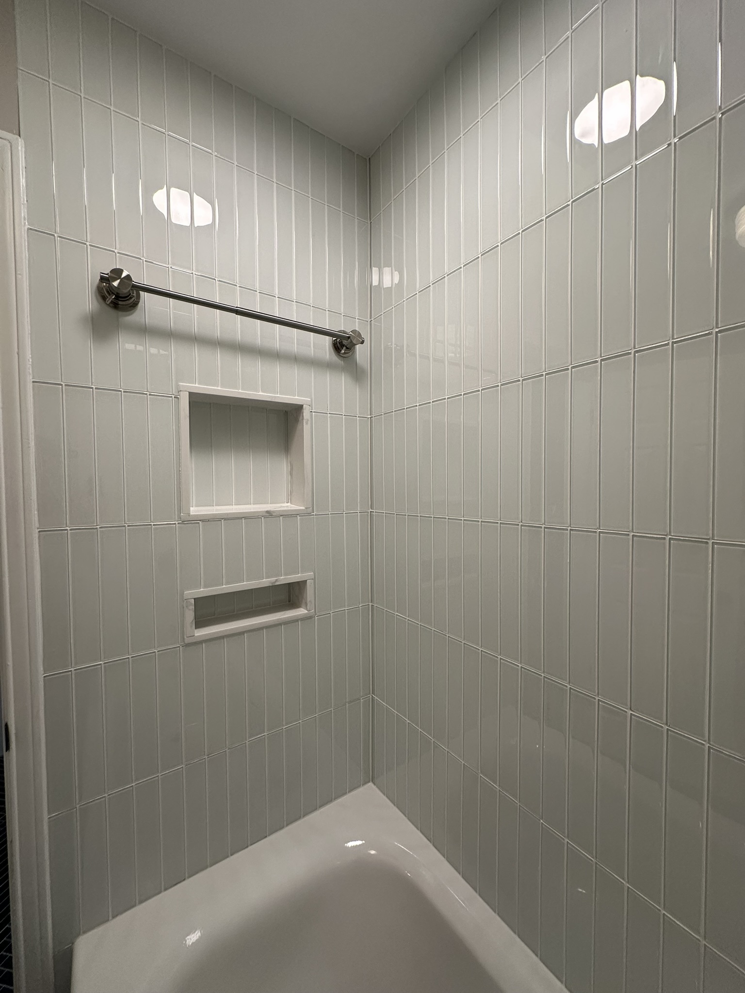 White vertical tile shower with built-in niches